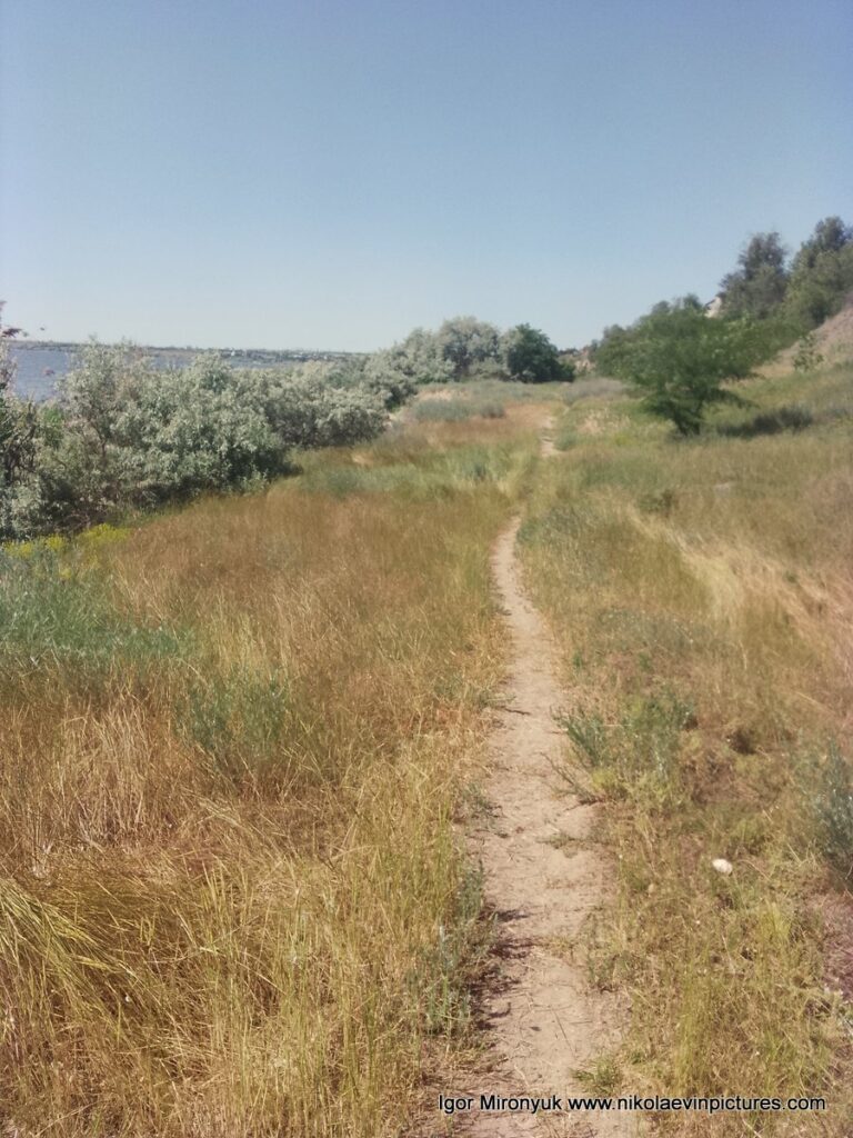 Долина, окружённая скалами с одной стороны и пляжами и водой - с другой.
