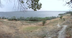 Долина, окружённая скалами с одной стороны и пляжами и водой - с другой.