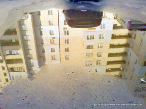 Отражение дома в луже.