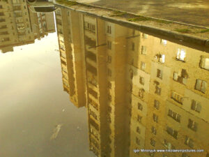 Отражение дома в луже.