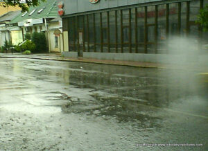 Машина проехалась по луже во время дождя в Николаеве и я увидел вихрь из брызг воды.