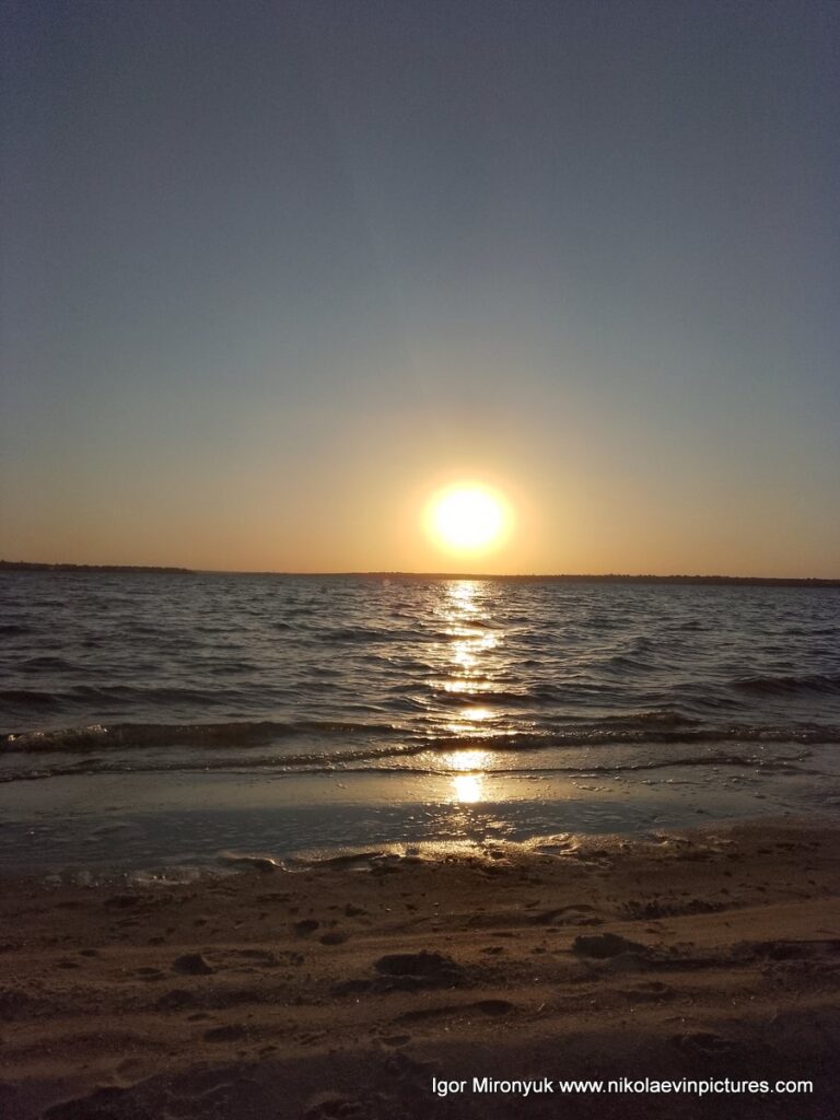 Большое солнце на горизонте, отсвечивая на воде. Сфотографировал с пляжа Скалы 6.