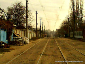 Улица в Николаеве с грунтовой, неасфальтированной дорогой и проложенными на ней трамвайными рельсами.